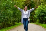 Mujer durante su caminata diaria por por el parque Mujer disfruta de su paseo por una senda en el parque