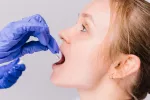 Toma de muestra de saliva para el diagnóstico de enfermedades Sanitario toma una muestra de saliva de la boca de una joven