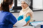 Mujer mayor se vacuna contra el virus respiratorio sincitial Sanitaria pone una vacuna a una mujer mayor