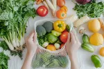 El reto de las 30 plantas a la semana Primer plano de las manos colocando verduras en una bolsa