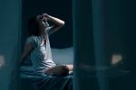 Despertares nocturnos pueden dañar el cerebro de las mujeres Mujer con sueño fragmentado se despierta en una habitación oscura