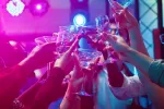 Jóvenes trasnochan y beben alcohol Amigos brindan con sus copas durante una fiesta en un local nocturno