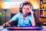 Efecto de los maratones de videojuegos en los niños Niño enfadado juega con el ordenador y auriculares