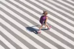 Niña acumulando pasos diarios mientras camina hacia la escuela Niña va al colegio con mochila caminando atravesando un paso de cebra