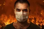 Incendio forestal y hombre con máscara para evitar el humo Hombre se protege con una máscara con un incendio forestal a su espalda