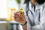 Frasco que contiene un líquido elaborado con compuestos de cannabis Una doctora muestra un frasco con con gotero de aceite de concentrado de cannabis