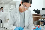 Investigadora sujeta una muestra de sangre que será analizada en un laboratorio Científica en laboratorio sujeta una muestra de sangre mientras toma notas