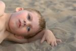 Niño autista tumbado en la playa