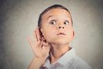 Un niño se toca la oreja demostrando atención