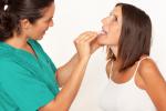 Una doctora explora la boca de una paciente