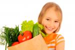 Una niña sostiene una bolsa con verduras