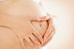 Embarazada formando un corazón con sus manos sobre el vientre