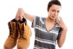 Mujer sujetando unas botas que desprenden mal olor