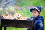 Niño pequeño contemplando el fuego de una barbacoa