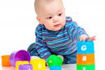 Un niño pequeño juega con unos cubos de colores