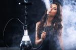 Chica adolescente fumando en shisha