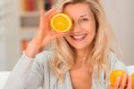 Mujer madura comiendo naranjas para mejorar la degeneración macular
