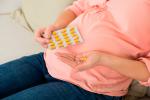 Una embarazada se dispone a tomar un suplemento vitamínico