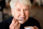 Mujer adulta mayor tomando probióticos para mejorar el deterioro cognitivo leve