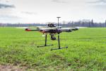 Un dron a punto de aterrizar sobre un terreno llano