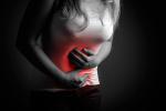 Una mujer se agarra el abdomen dolorido