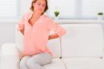 Mujer con fibromialgia sentada en el sofá