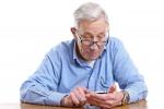 Hombre mayor consulta un teléfono móvil