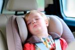 Un niño pequeño duerme en el interior de un coche