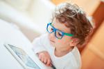 Niño pequeño con gafas mirando una tablet