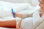 Mujer embarazada usando el móvil