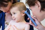 Doctora examina a niña pequeña con otitis
