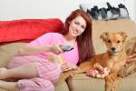 Una chica y su perro viendo la televisión
