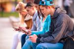 Varios adolescentes consultan las redes sociales en sus móviles