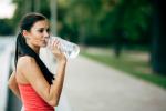 Chica bebiendo agua para hidratarse en verano