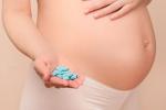 Mujer embarazada con pastillas de viagra en la mano