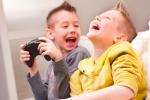 Dos niños ríen a carcajadas con un videojuego