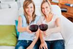 Dos mujeres brindan con sendas copas de vino tinto