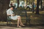 Mujer leyendo sentada en un banco del parque