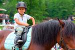 Niño pequeño aprendiendo a montar a caballo