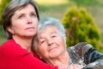 Una cuidadora abraza a una anciana en situación de dependencia