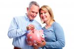 Una pareja de mediana edad guarda dinero en una hucha
