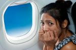 Mujer asustada en el interior de un avión