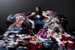 Mujer sentada sobre una pila de ropa