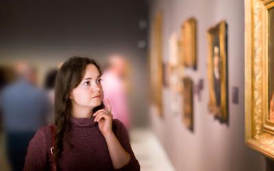 Mujer observando la belleza de un cuadro en el museo