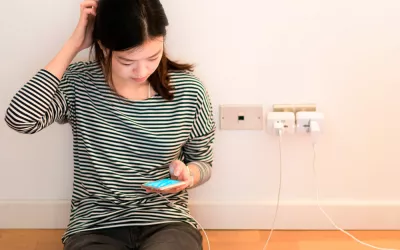 Síndrome de la batería baja, la ansiedad de la generación selfie Una joven mira con preocupación el nivel de batería de su móvil