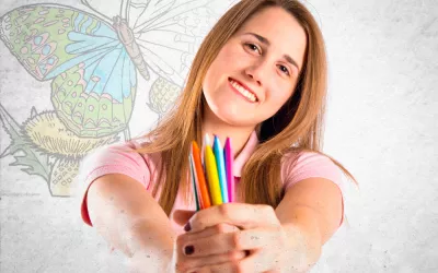 Una mujer muestra un puñado de pinturas de colores