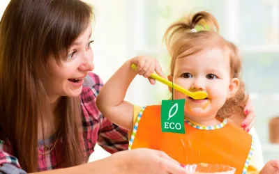 Una mama ofrece un alimento ecológico a su bebé