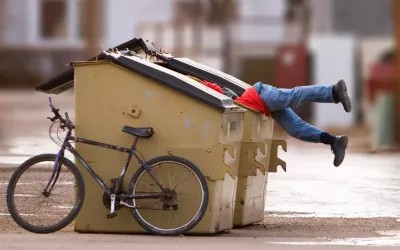 Friganismo, cruzada contra el despilfarro Un hombre busca en el interior de un contenedor de basura