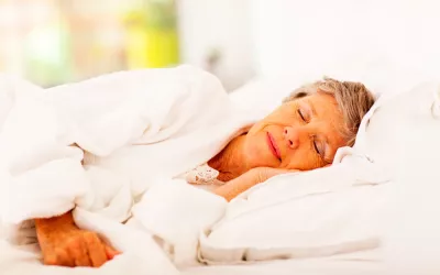 Una mujer mayor duerme en su cama