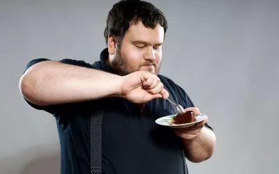 Persona obesa comiendo dulce